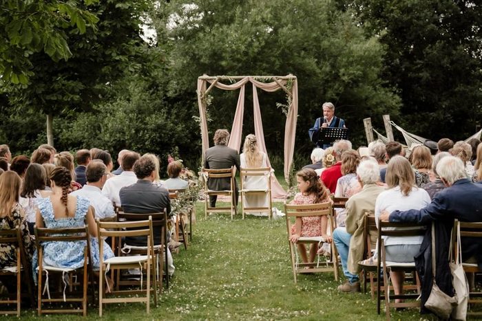 Buitenceremonie onder een bloemenboog