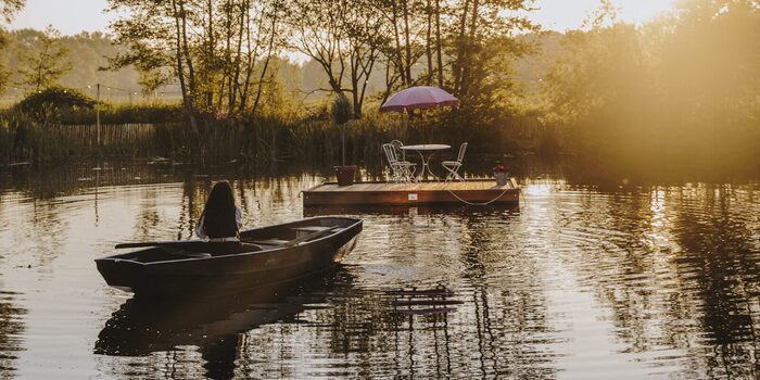 Roeiboot op het meer bij zonsondergang